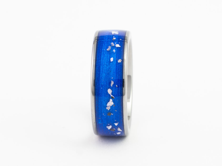 Silver tungsten ring with blue inlay containing white flecks, on white background.
