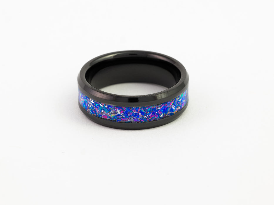 Black tungsten ring with purple-blue crushed opal inlay on white background