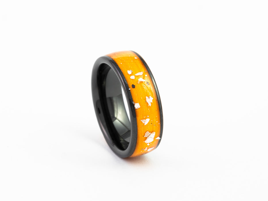 Side view of the Black Ceramic Ring with orange resin and Mother-of-Pearl flake inlay.