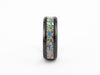 Side profile close-up of the Black Ceramic Ring showing the colorful fire opal flake inlay band detail.