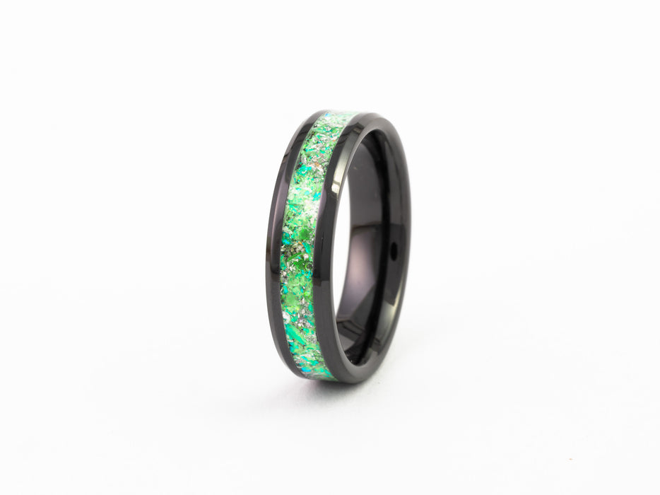 Black Ceramic Ring with bright green fire opal flake inlay band on a white background.