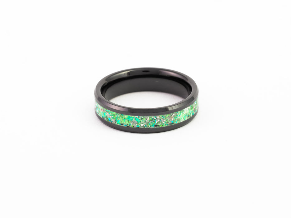 Top view of the Black Ceramic Ring showcasing the wide green fire opal flake inlay and the detailed edges.