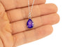 Sterling silver teardrop pendant with deep purple resin and silver flakes, shown in the palm.
