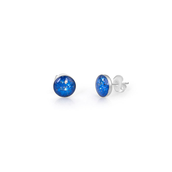 Pair of sterling silver stud earrings featuring round blue opal resin inlays with the posts clearly visible.
