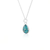Sterling silver chain necklace with a pear-cut teardrop pendant featuring vibrant teal blue resin and internal silver flake accents.