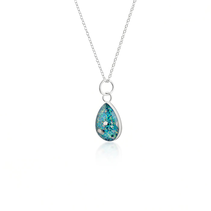 Sterling silver chain necklace with a pear-cut teardrop pendant featuring vibrant teal blue resin and internal silver flake accents.