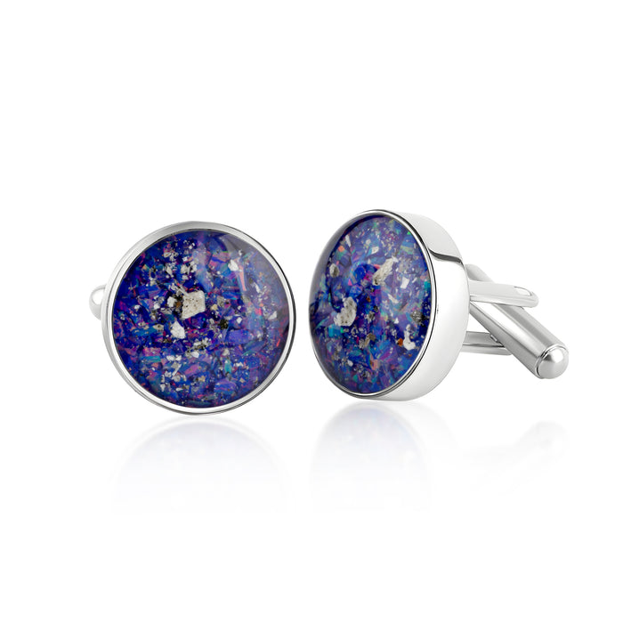 Pair of sterling silver cufflinks featuring round blue and purple resin inlays with scattered silver flakes, presented on a white background.