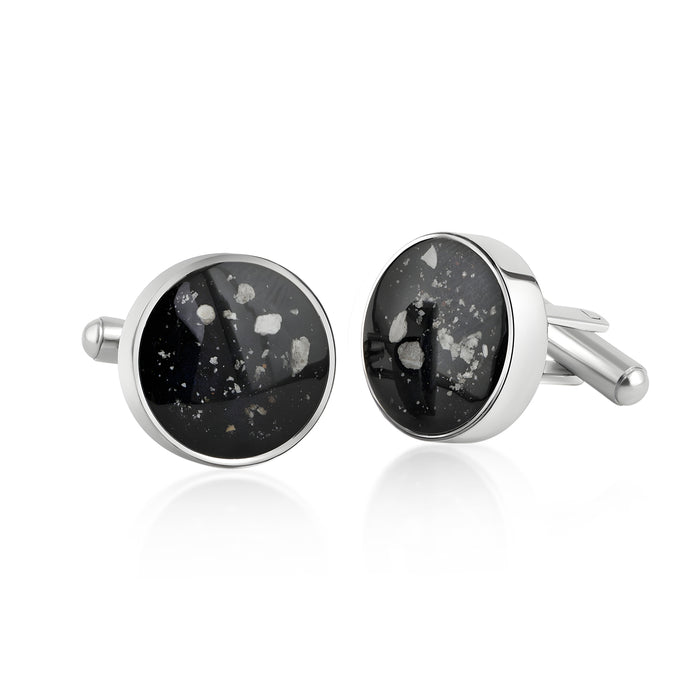 Pair of sterling silver cufflinks featuring round black resin inlays with scattered white and silver flake accents.