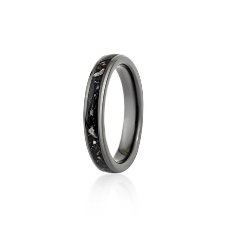Thin black band ring featuring a continuous inlay of black resin with scattered white and silver flakes.