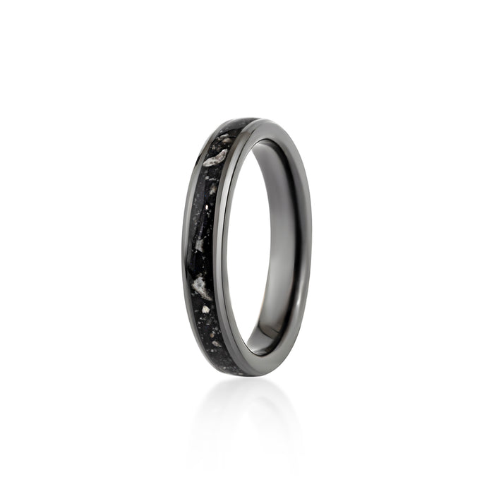 Thin black band ring featuring a continuous inlay of black resin with scattered white and silver flakes.