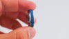 Short demonstration video featuring a hand rotating a silver band ring with a vibrant blue opal resin inlay.