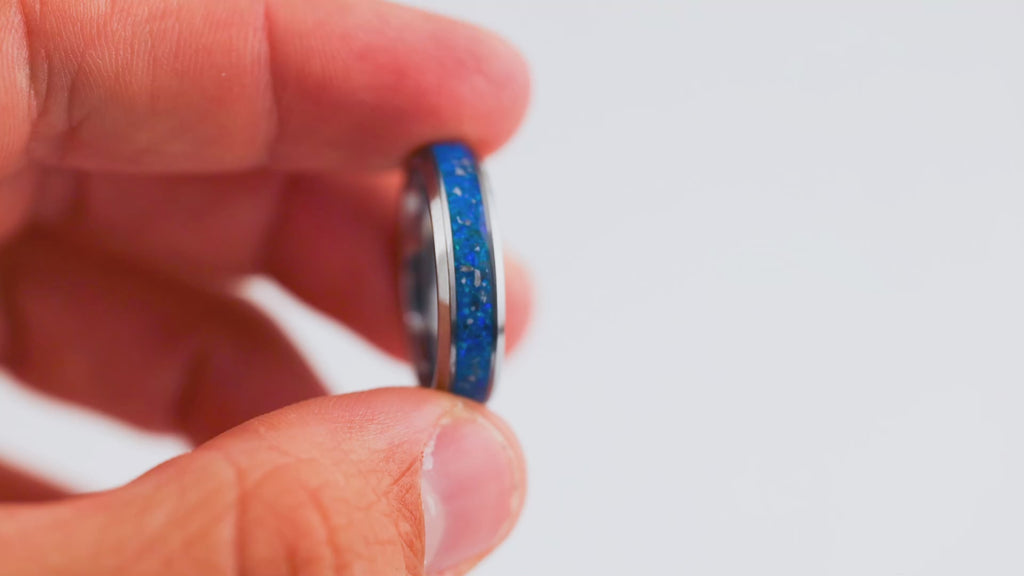 Short demonstration video featuring a hand rotating a silver band ring with a vibrant blue opal resin inlay.