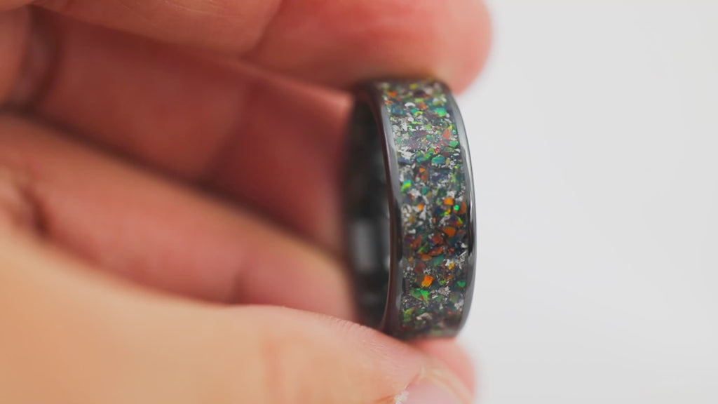 Close-up video of the Black Ceramic Ring rotating 360 degrees, showcasing the dark multicolored fire opal inlay.